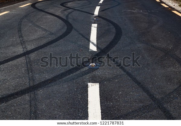 Car tyre skid marks on a\
rural road