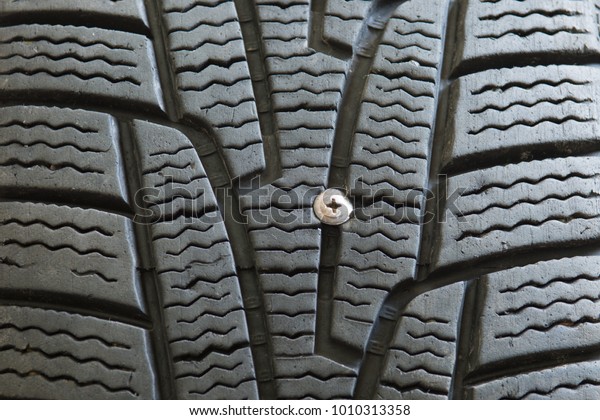 Car\
tyre stung with nail. The nail stung the black rubber tire of the\
old car it is a part of the wheel that has\
damage