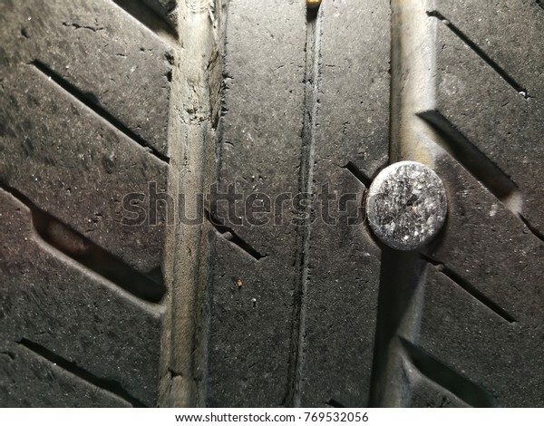Car\
tyre stung with nail. The nail stung the black  rubber tire of the\
old car it is a part of the wheel that has\
damage