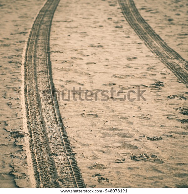 car tyre tracks on the beach sand in\
perspective - instant vintage square\
photo