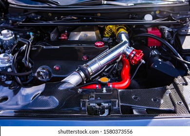 Car Under Hood Showing High Performance Transverse Engine With Tuning And Modification, Red, Yellow, Silver, Chrome And Carbon Fiber Clean Parts