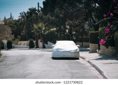 Car under a protective cover near house