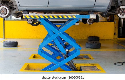 Car Under Repair On Hoist At Service Station.