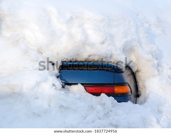 Car\
under the snow. A lot of snow after a snowfall. The car is\
completely covered with snow. Only a small fragment of the car is\
visible from the snowdrift. Cold and snowy\
climate.