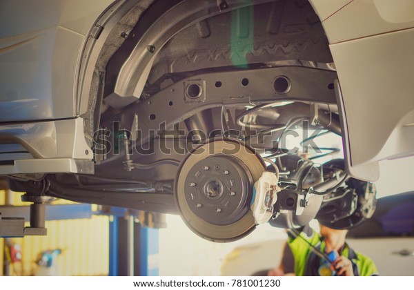 Car\
underbody,chassis and disk of car.And car shaft cleaning and\
maintenance at service station,close\
up.