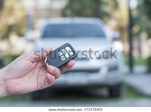 Car valet parking service
business concept with people handling car key on blur parking lot
background