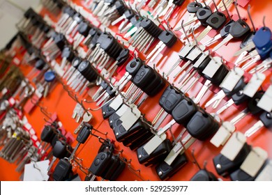 Car And Van Keys Hanging On Hooks At Locksmith Stand At Workshop
