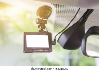 car video recorder installed on the window,with blank screen,copyspace ,selective focus.at sunset,vintage color