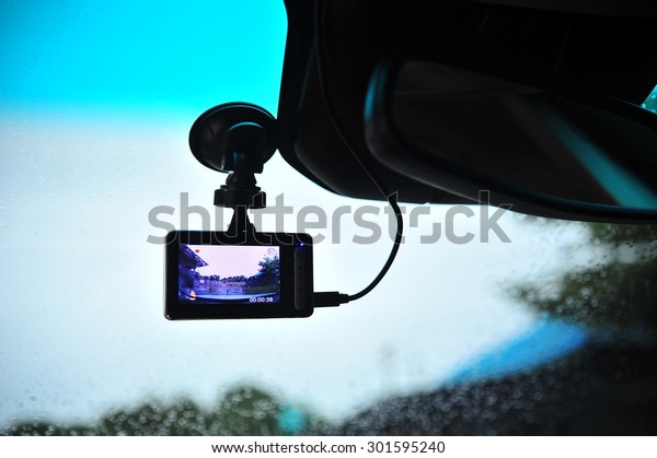 Car video recorder next to a rear view mirror\
in highway sunset.\
