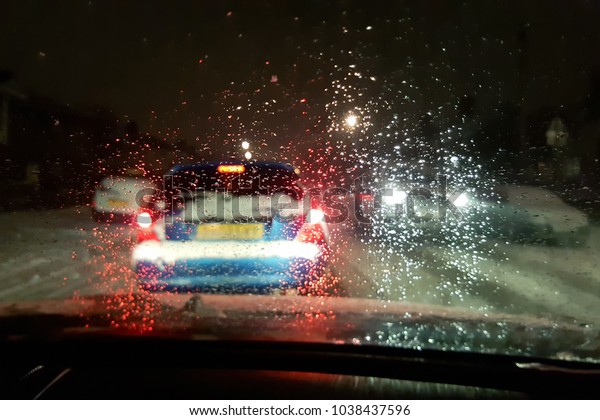 In car view of snow fall storm in the UK causes\
traffic congestion at night