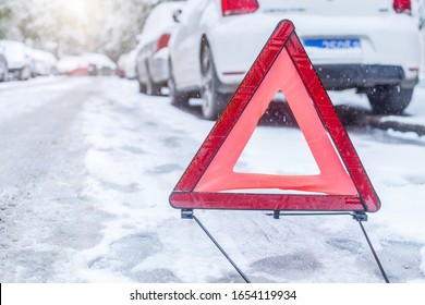 Car Warning Triangle On The Road Against The City In The Evening