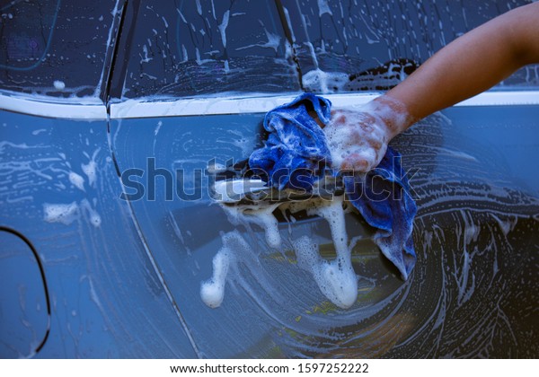 Car\
wash, bubbles with cars, hands are cleaning the\
car\
