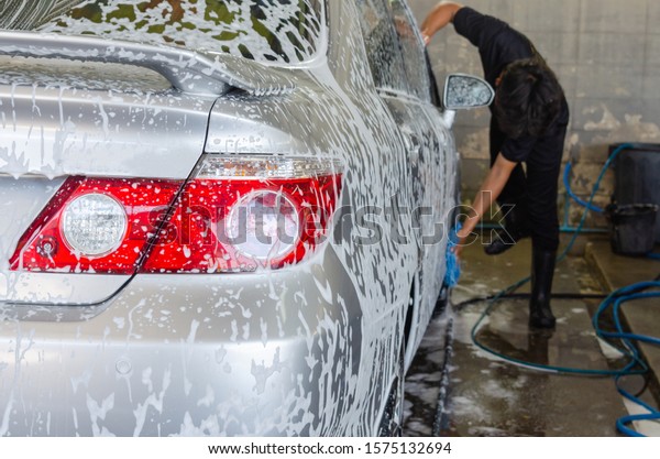 Car wash bubbles with foam in the station.\
Focus on the taillight
