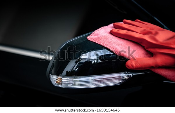Car wash\
cleaning concepts . Auto service staff cleaning car with microfiber\
cloth in Interior car console\
