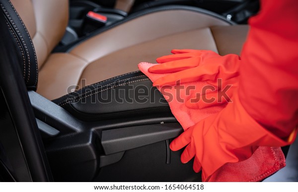 Car wash\
cleaning concepts . Auto service staff cleaning car with microfiber\
cloth in Interior car console\

