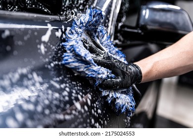 car wash employee thoroughly washes a modern ca - Shutterstock ID 2175024553