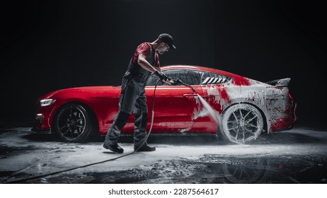 Car Wash Expert Using Water Pressure Washer to Clean a Red Modern Sportscar. Adult Man Washing Away Shampoo, Preparing a Muscle Car for Detailing. Creative Low Key Photo with Sport Vehicle - Shutterstock ID 2287564617