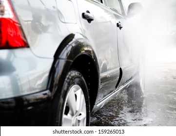 Car wash with flowing water and foam.