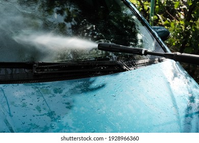 Car Wash At Home Alone. Car Wash High Pressure Close-up. A Man Washes A Green Car.