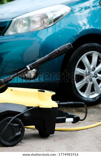 Car wash at home alone. Car wash high pressure
close-up. A man washes a green
car.