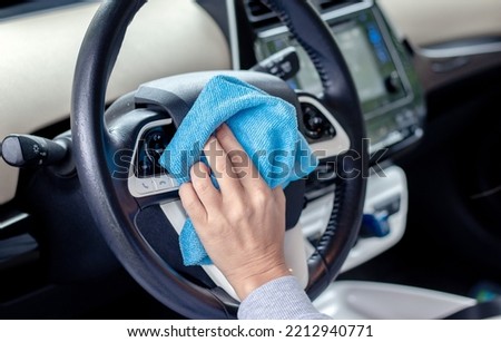 car wash and interior chemical cleaning concept.woman hand use microfiber cloth and spray to clean lateral door from inside,retractable rear view mirror,steering wheel.modern hybrid vehicle clean home Imagine de stoc © 