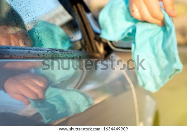 Car wash. A man washes a car
under the pressure of water and rubs the glass. Car care
concept