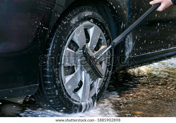 Car wash\
outdoor. Car wheel washing with a brush.\
