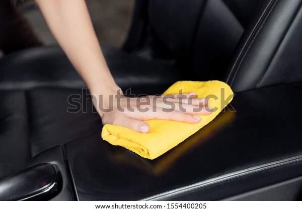 Car wash service, girl worker cleaning\
interior modern microfiber and console\
auto.
