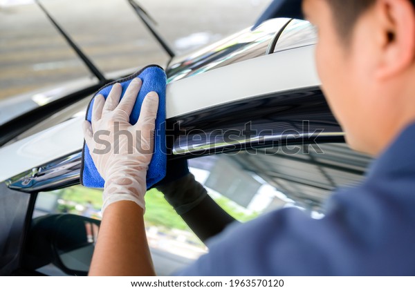Car wash service personnel clean their cars with\
microfiber cloths. Details and valet concept Selective focus\
Close-up view