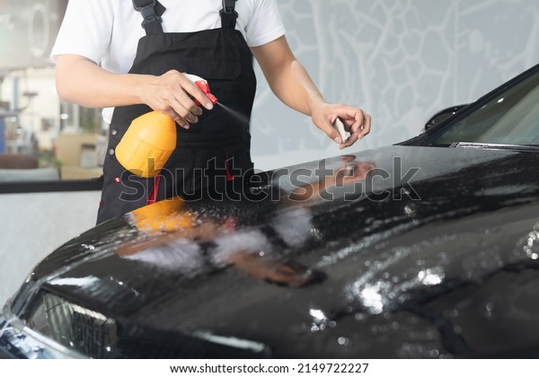 Car wash shop\
worker cleaning dust from\
car