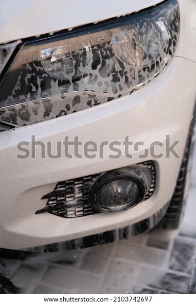 car wash with white soap,\
foam on the body. Cleaning Car Using Washing with soap. High\
Pressure Water.