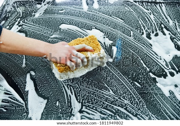 Car washer\
wipes windscreen with shampoo\
sponge
