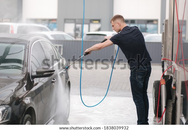 Car washing. Cleaning car using high pressure
water. Man washing his car
outdoor