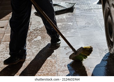 Car Washing. Guy Is Brushing Stone Floor In Open Garage