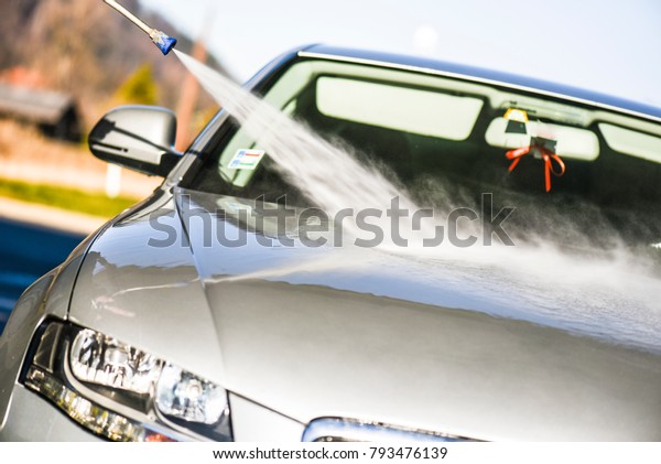Car\
washing with jet.  Cleaning car at wash\
station.