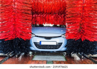 Car Washing Machine. Auto Brush Washer Clean Blue Car On Automatic Carwash Station. Automated Car Washing Machine Background