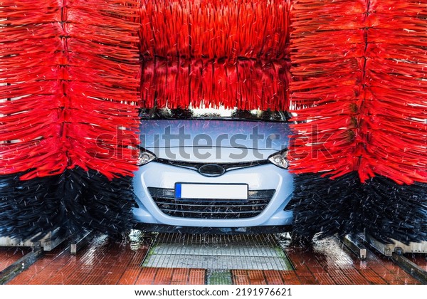 Car washing machine. Auto brush washer clean
blue car on automatic carwash station. Automated car washing
machine background