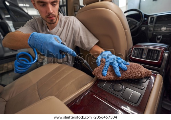 Car washman worker cleaning vehicle at renewing\
service station shop