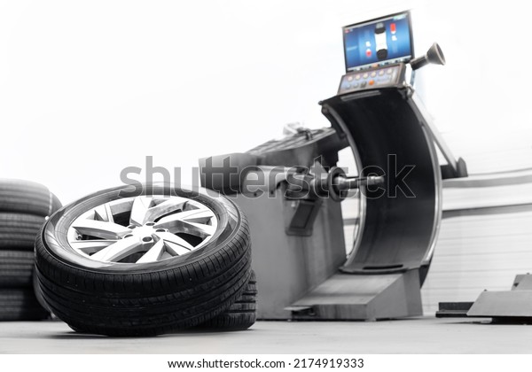 Car\
wheel balancing in tire service station on\
machine.
