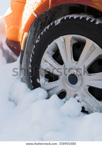 Car wheel covered with\
snow in winter.