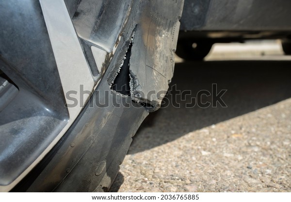 Car wheel with a flat tire on the roadway after\
blow-out. Closeup