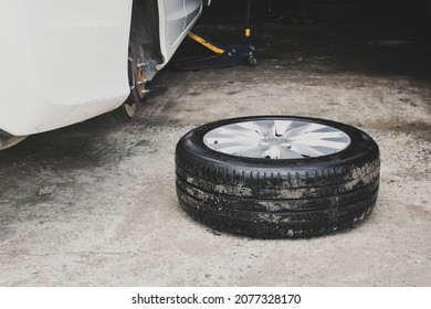 Car Wheel Laid On The Floor And A Broken Car In The Auto Repair Shop Service 