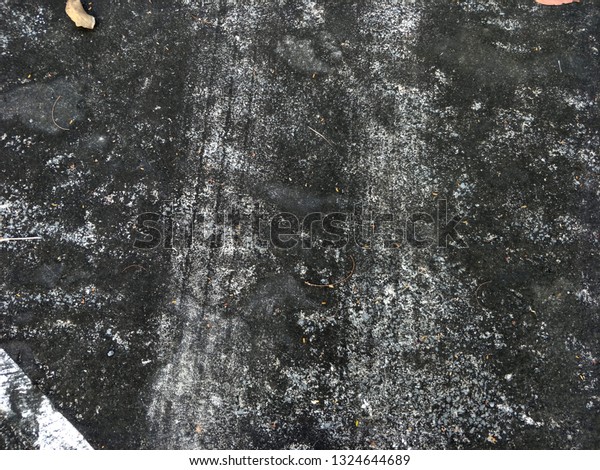 Car wheel\
marks on old roads marked on wet\
asphalt.