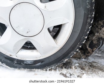 Car Wheel On Slow Covered Surface At Winter Day, Flat Cast Silver Disc, Closeup