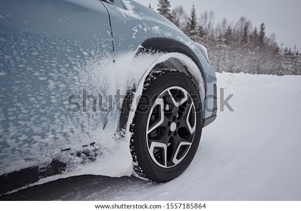 Car wheel on the snow in winter, after driving\
in snowfall, close-up, side\
view