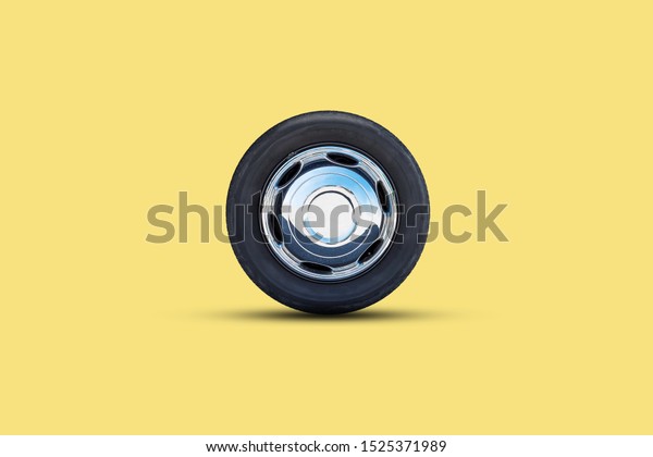 Car wheel on a yellow\
background. Isolated. Transport. Spare parts. Sale, repair of auto\
wheels.