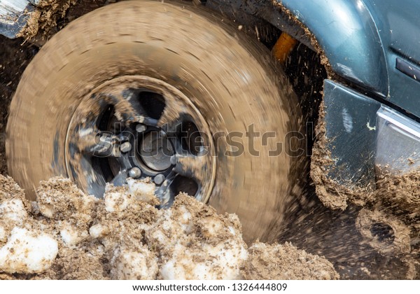 Car wheel slips in\
the dirt in nature .