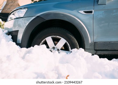 Car with wheel stuck in snow after heavy snowfall