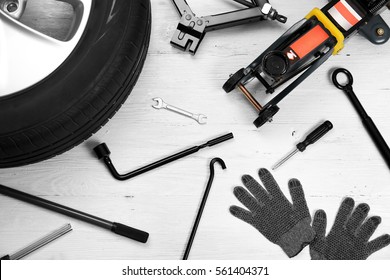 Car Wheel With Tools On Wooden Background