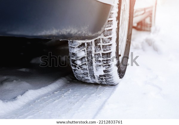 A car wheel with\
winter tires and a footprint on a snowy road. Snow drifts, ice,\
insurance event concept